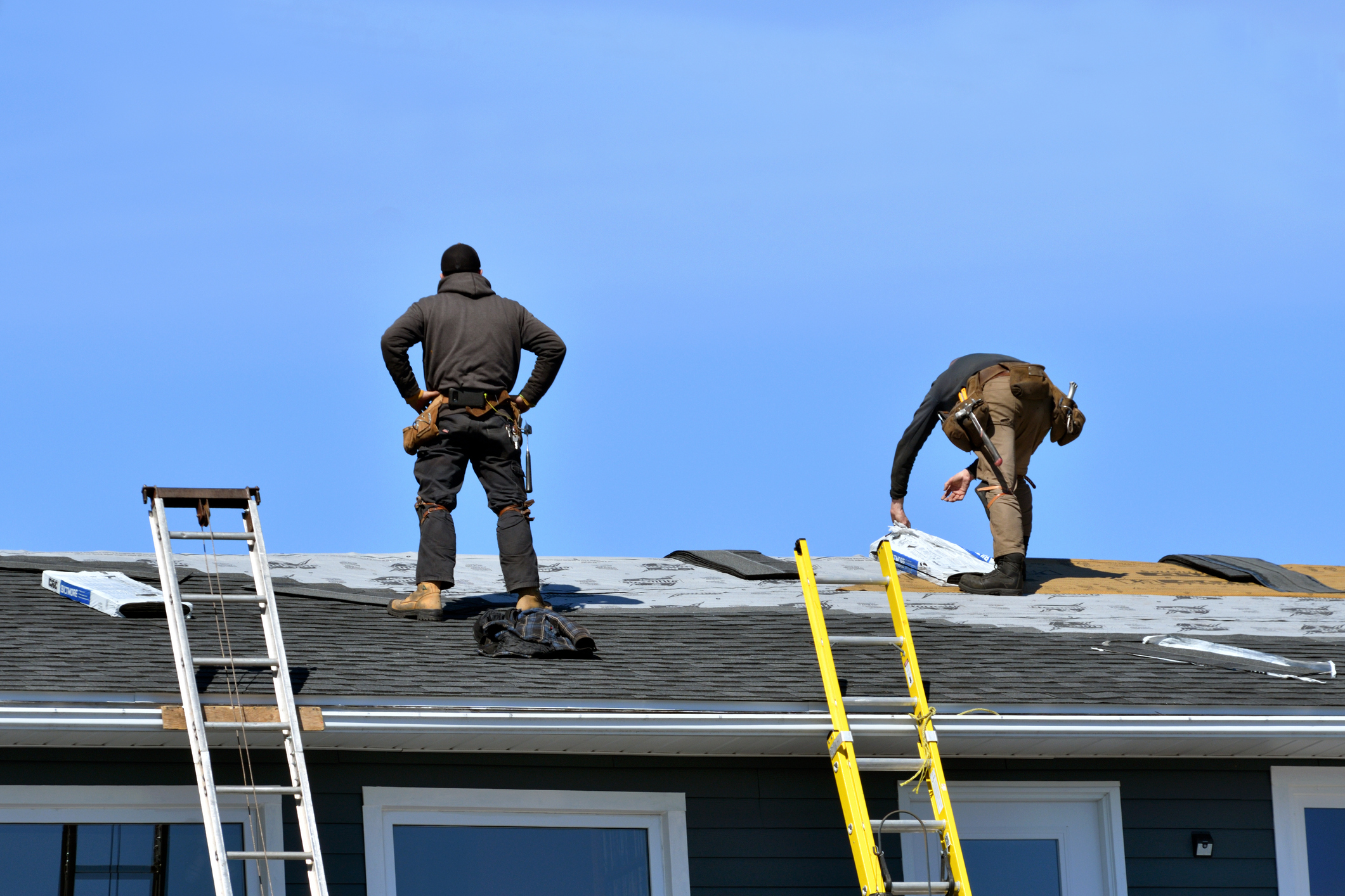 Two Men in Gray Working Clothes Doing Roofing Services